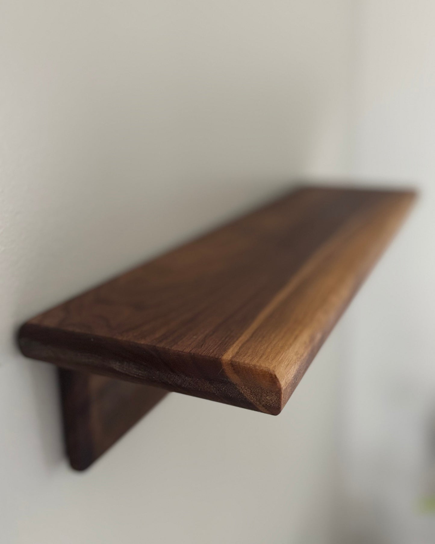 Wooden shelf against a white wall