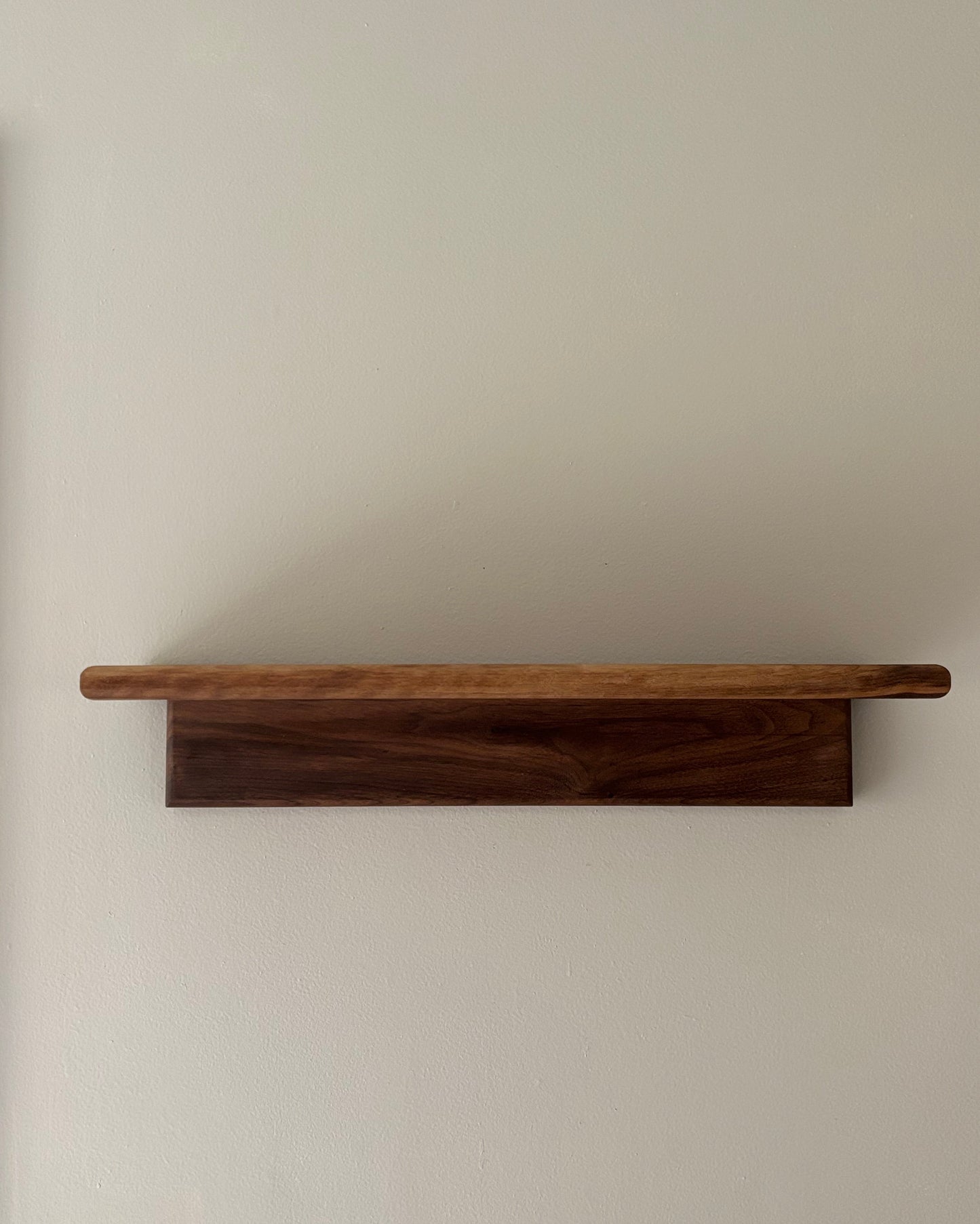 Wooden shelf mounted on a plain wall